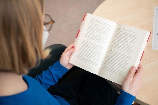 Fotografie - Eine Person liest ein Buch.