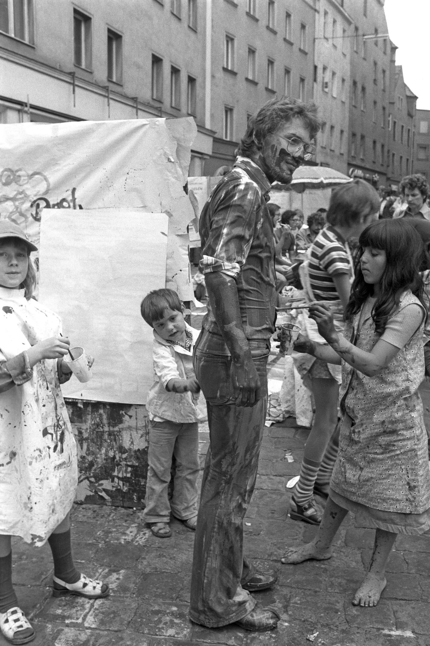 Fotografie: Kinder malen einen Mann an.