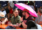 Fotografie: Menschen mit pinkem Schirm als Sonnenschutz