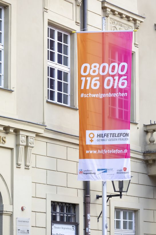 Fotografie: Die Fahne des Bundesnotruftelefons mit dem Logo vom Runden Tisch gegen häusliche Gewalt 