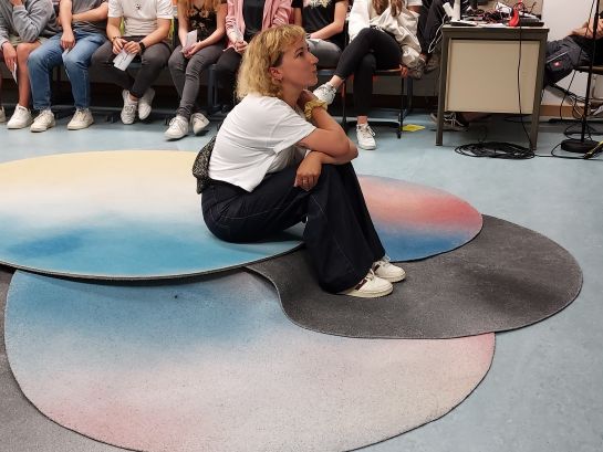 Frau schaut sitzend am Boden, Theateraufführung
