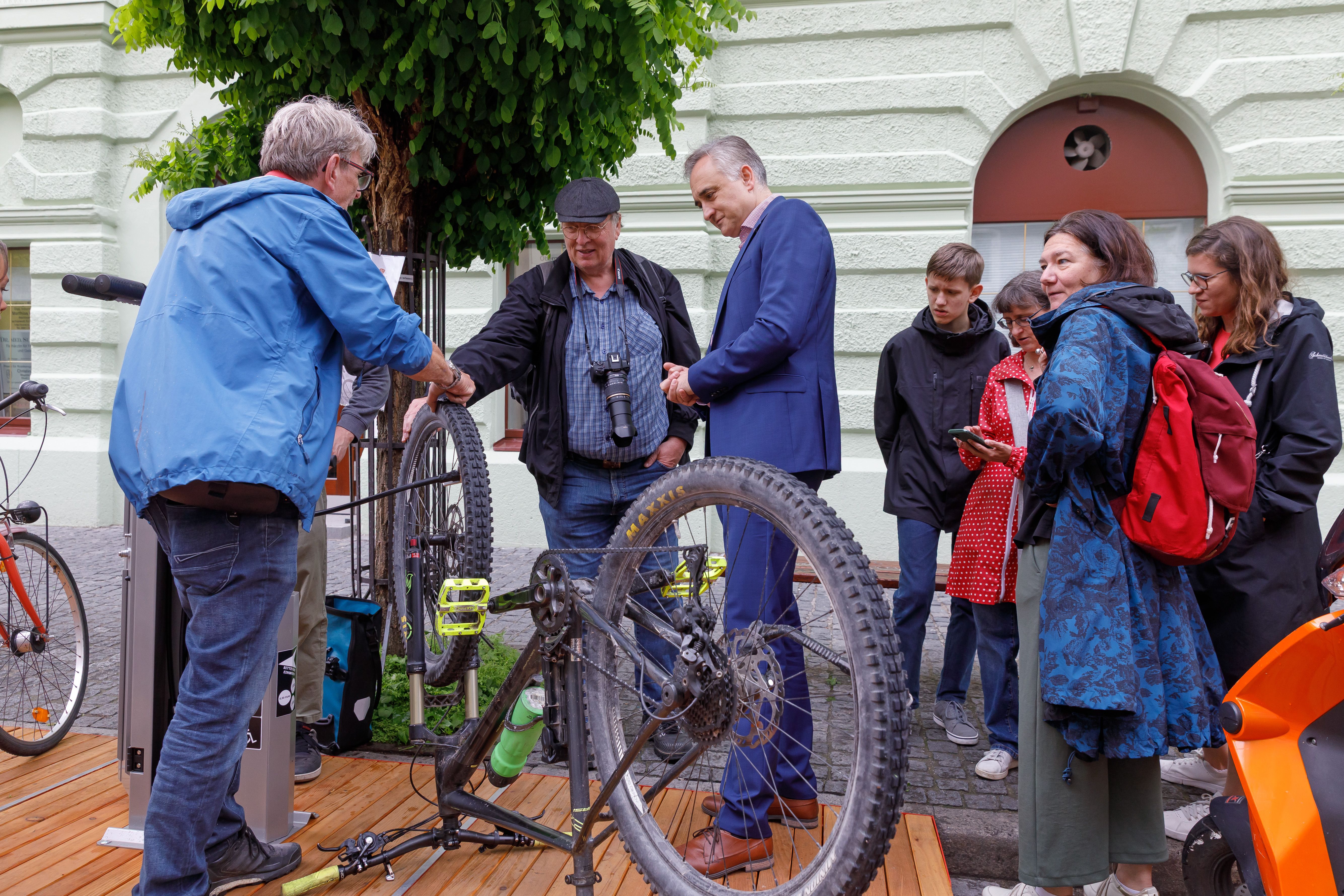 Fotografie: Stadtrat Dr. Thomas Burger begutachtet die neu errichtete Fahrradreparaturstation.