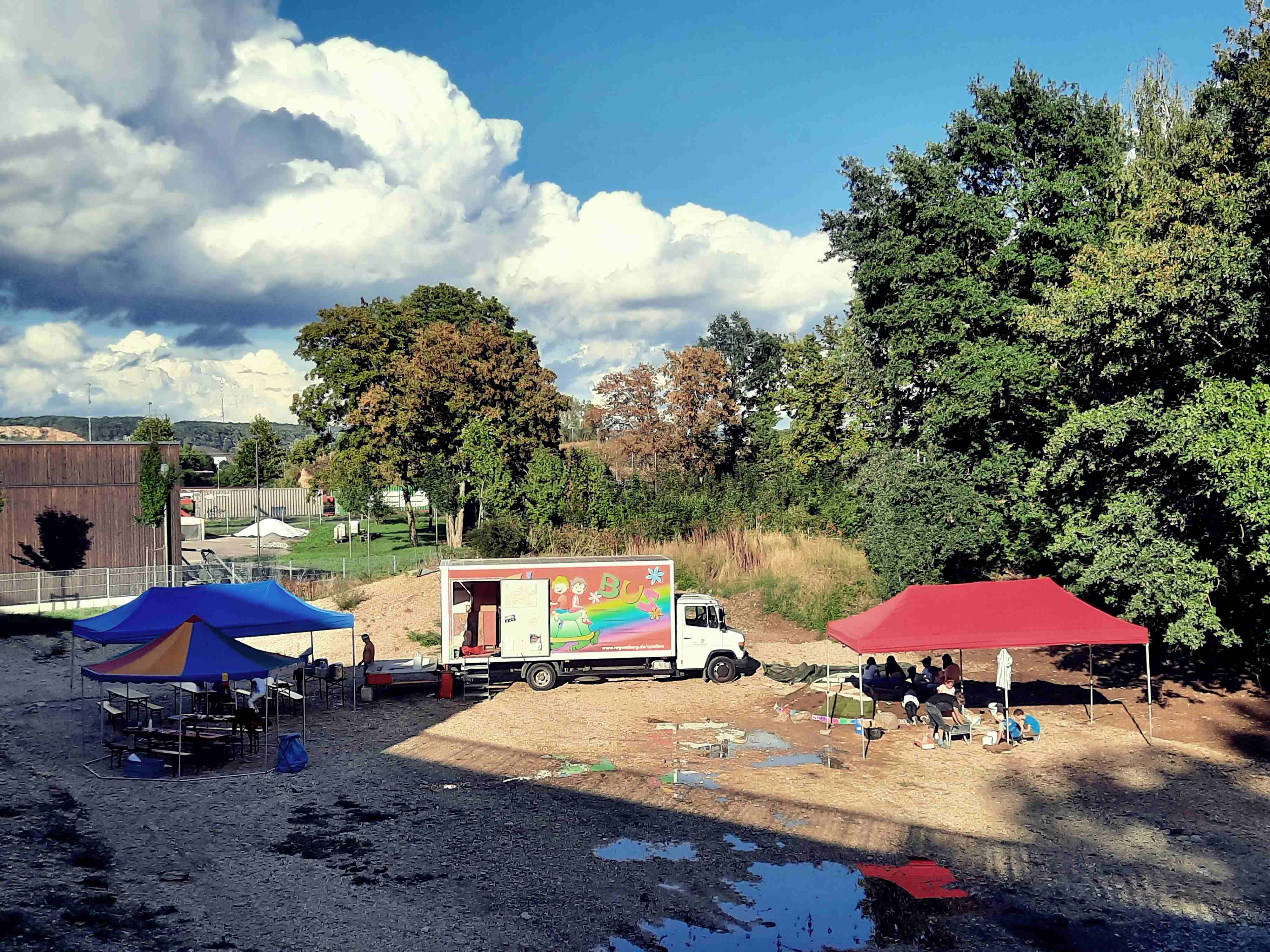 Auf dem Foto sind der Spielbus und mehrere Pavillons zu sehen.  