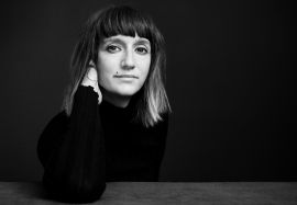 Zu sehen ist die Künstlerin Vanessa Hafenbrädl im Portrait. Sie hat dunkle, mittelkurze Haare und braune Augen.