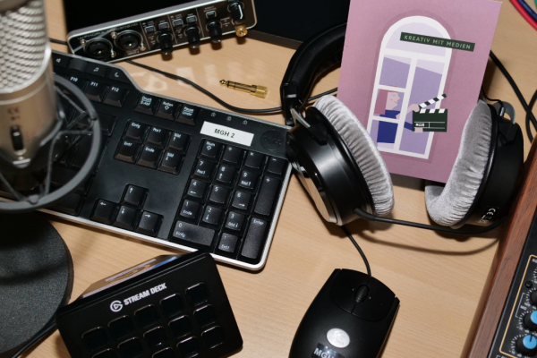 Symbolbild mit Mikrofon, Tastatur, Kopfhörern, Mischpult und MGH-Flyer