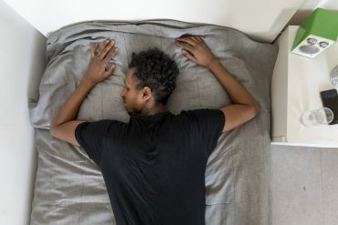 Jugendlicher liegt auf dem Bett