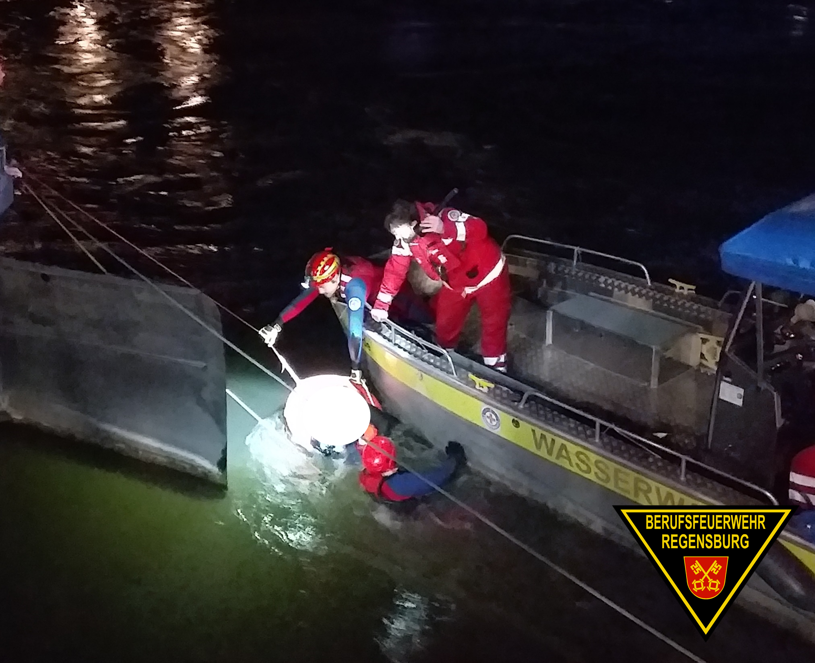 Einsatzkräfte retten die Person auf ein Boot