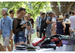 Fotografie: Eine Frau betrachtet an einem Stand Second-Hand-Waren.