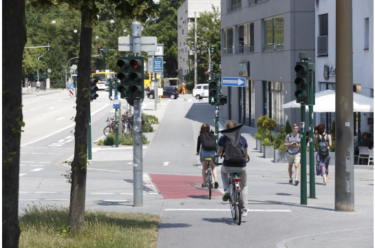 Fotografie: Radfahrer überqueren eine Kreuzung.