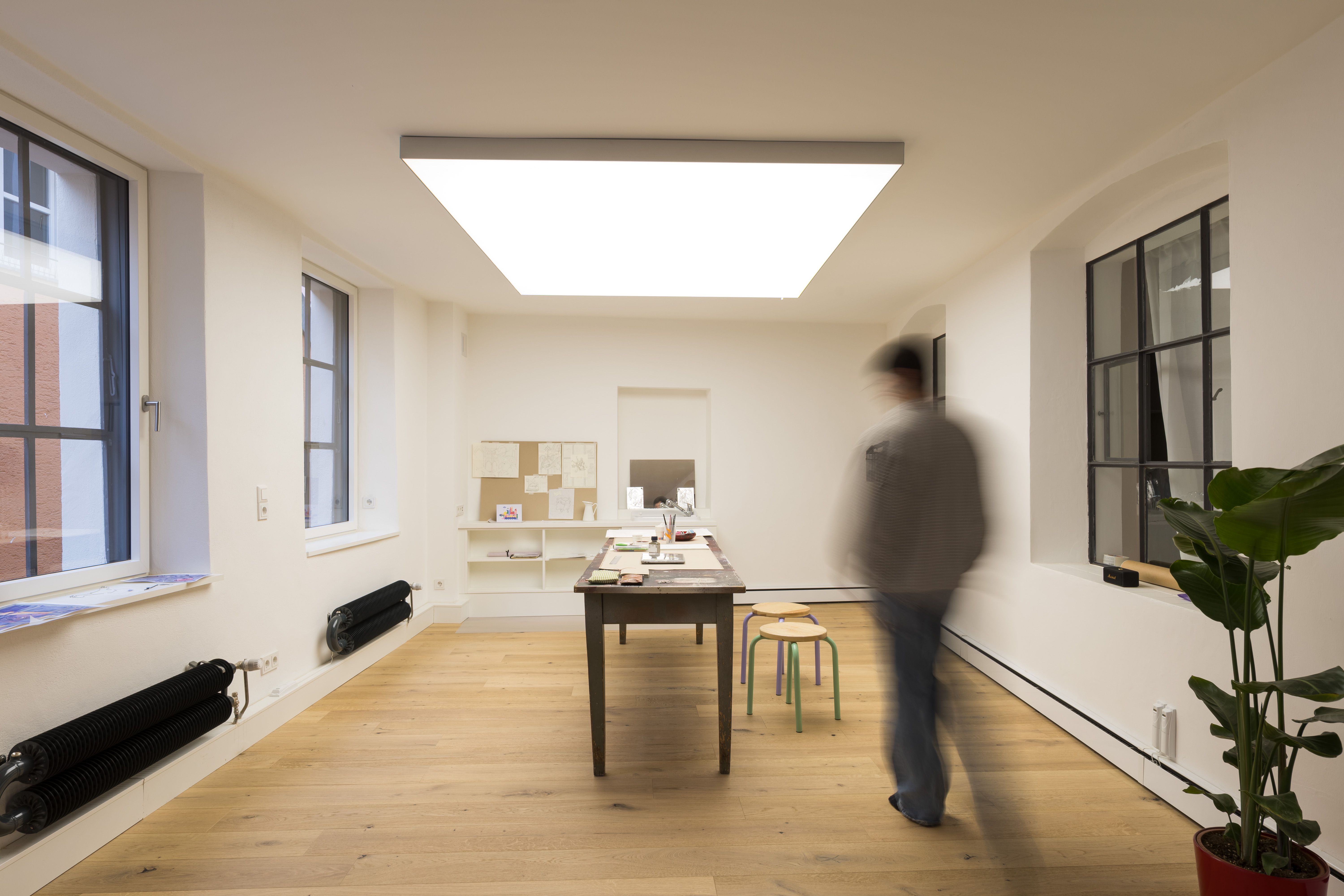 Fotografie - Atelierwohnung 2 - Zu sehen ist eine verschwommende männliche Silhouette, die in Richtung Studio läuft.