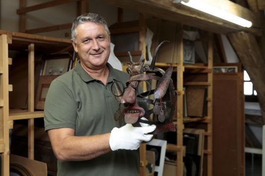 Fotografie: Michael Preischl präsentiert eine Schandmaske um 1620, die im Depot aufbewahrt wird. (C) Bilddokumentation Stadt Regensburg