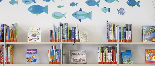Forografie - Über den Kinderbücher-Regalen in der Stadtteilbücherei Ost schwimmen blaue Fische an der Wand. (C) Bilddokumentation Stadt Regensburg