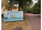 Fotografie eines blauen Banners mit dem Spruch "Fahrradstraße ist... nebeneinander fahren."