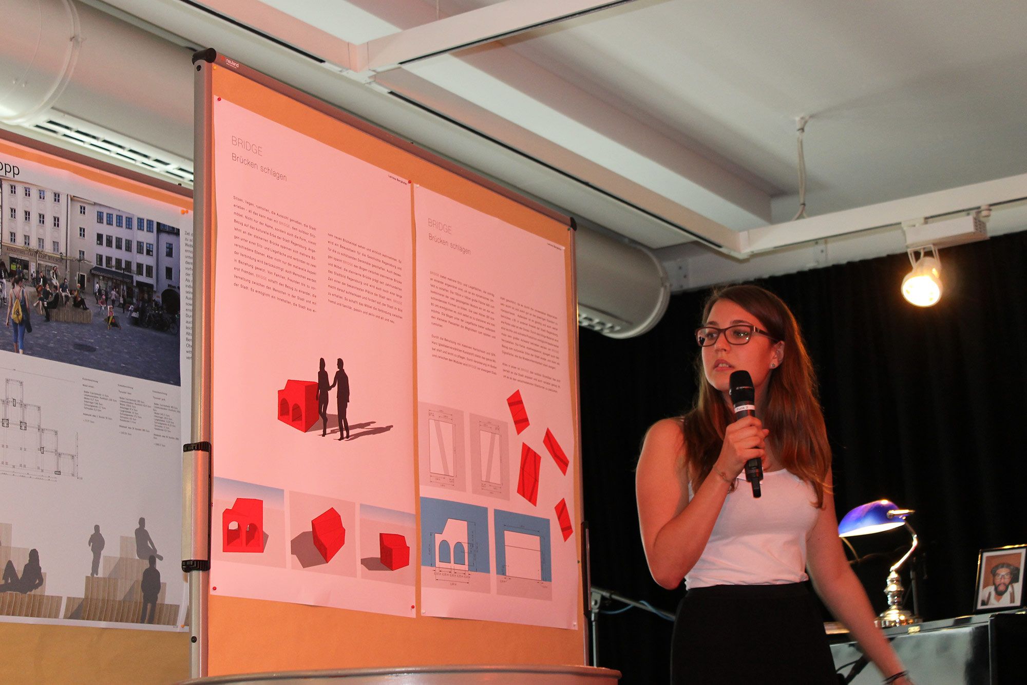 Aktion Sondermöbel - Foto einer Veranstaltung - vor einer Infowand am Mikrofon Larissa Berghofer