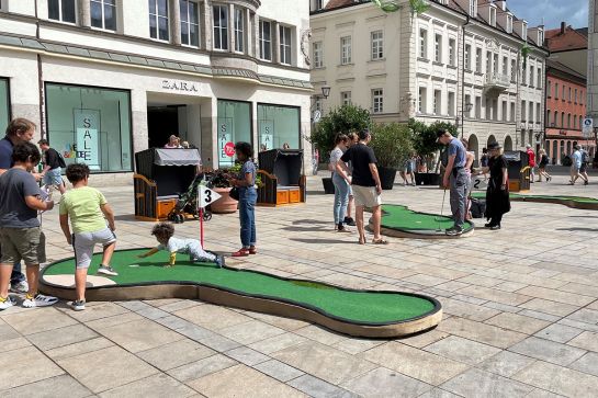 Menschen spielen Minigolf in der Stadt