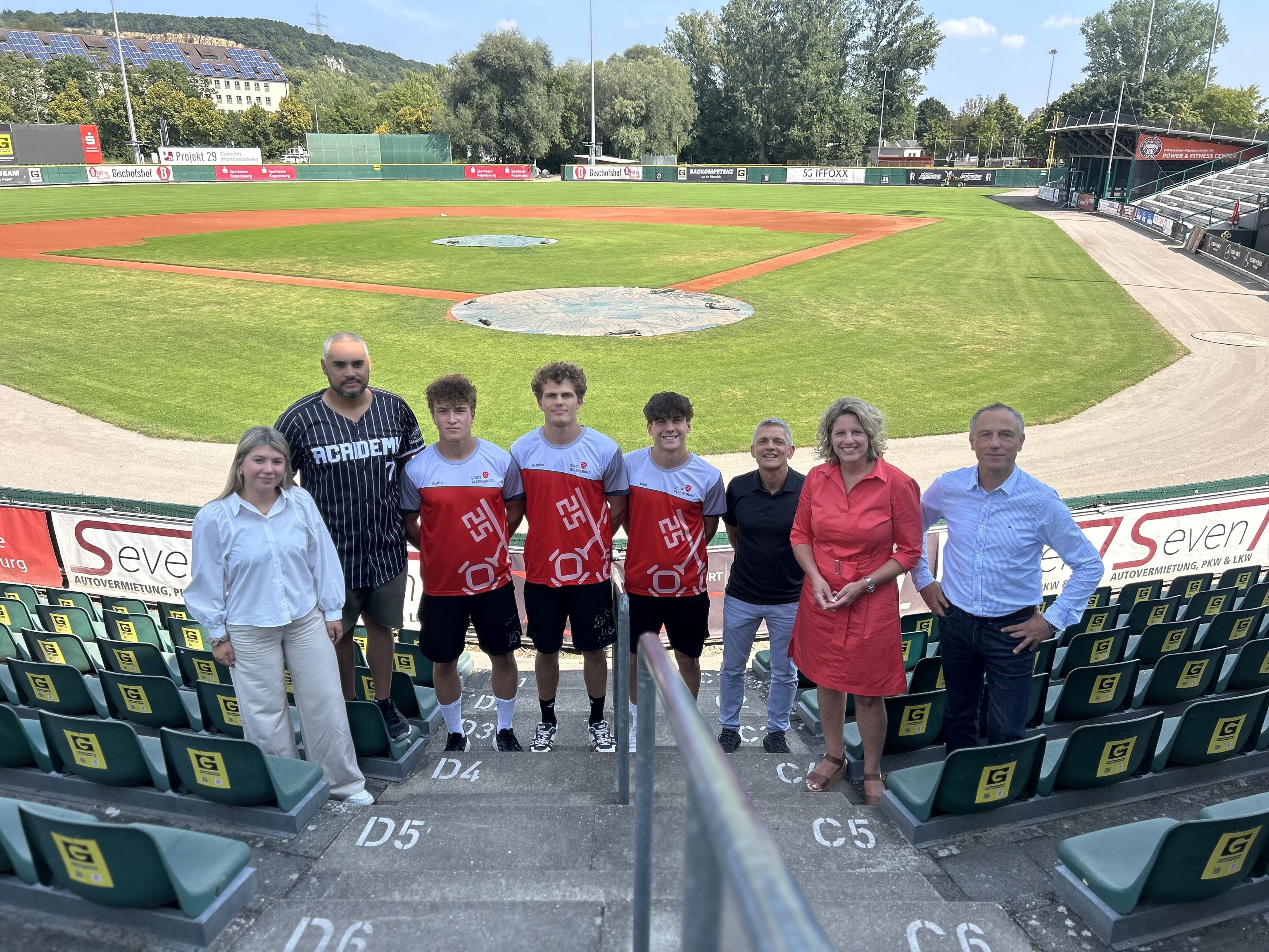 Fotografie – (v. l. n. r.) Lena Kröninger (Amt für Sport und Freizeit), Alejandro Sanchez (Academy Headcoach), Robin Spies (BBSV), Matthias Bullmann (BBSV), Jona Widmann (BBSV), Armin Zimmermann (Regensburg Legionäre e.V.), Bürgermeisterin Astrid Freudenstein, Christian Goß (Leiter des Amtes für Sport und Freizeit)