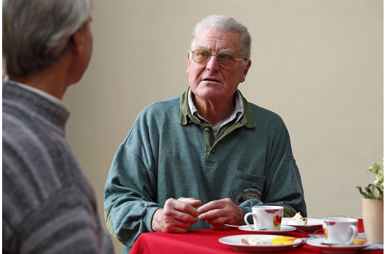 Themenbild Senioren - Hilfe im Alter - Fotografie - zwei Senioren sitzen an einem Tisch im Gespräch
