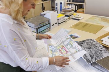Fotografie: Annemarie Reck betrachtet Pläne des Neupfarrplatzes.