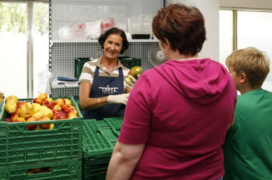 Fotografie - Frau verteilt Obst bei der Tafel