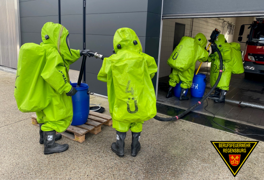 Fotografie: Einsatzkräfte der Feuerwehr mit Chemikalienschutzanzügen bei einer Übung.