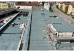 Fotografie - Blick aus dem 5. OG auf den Bauabschnitt 3b. Das Dach wurde mit Teerbahnen verschweißt. Auf dem Dach der Fahrzeughalle entsteht später eine Dachterrasse mit Aufenthaltsmöglichkeit für die Mannschaft. (C) Berufsfeuerwehr Regensburg, Christoph Tresch