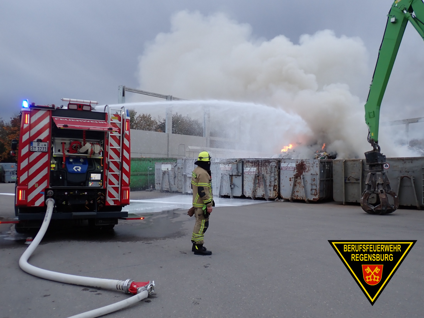 Feuerwehrleute löschen brennenden Müllhaufen