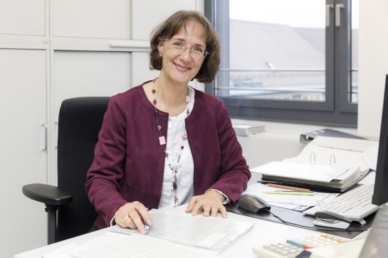 Fotografie: Katrin Hattwig sitzt an ihrem Schreibtisch. (C) Bilddokumentation Stadt Regensburg