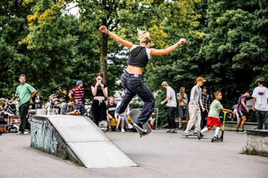 FOtografie: Skaterin springt mit Skateboard im Skatepark