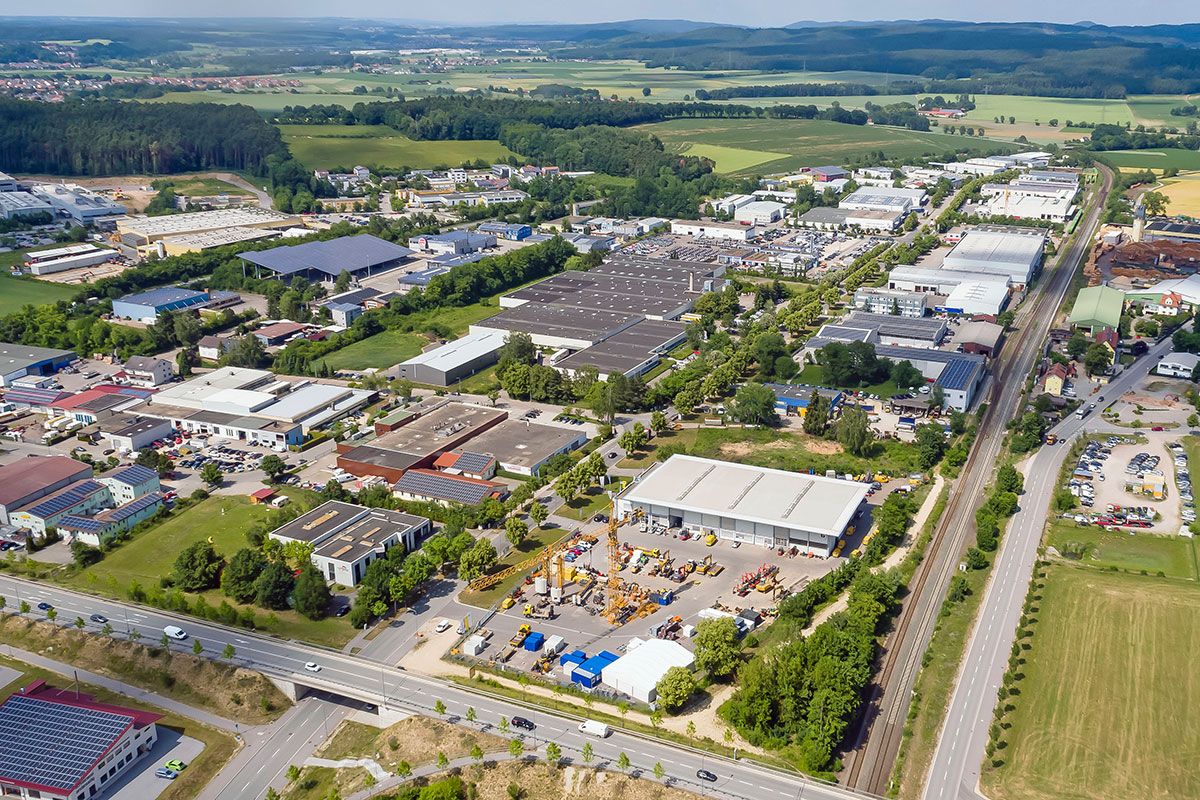 Fotografie - Luftbildaufnahme vom Gewerbegebiet Haslbach, links im Bild Gebäude von Haslbacher Unternehmen, rechts im Bild ist das Industriestammgleis Wutzlhofen sowie die Kreisstraße R6 Richtung Wenzenbach zu sehen