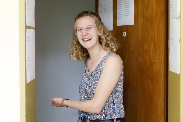 Frau Jana Jolliffe lässt Gäste in eine Wohnung eintreten.
