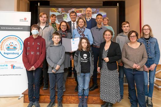 Fotografie - Gruppenbild mit Oberbürgermeisterin Maltz-Schwarzfischer, Bürgermeisterin Dr. Astrid Freudenstein und weiteren Beteiligten an der Jubiläumsfeier zur Siegelentfristung des Programms Kinderfreundliche Kommunen (C)  Stadt Regensburg, Bilddokumentation