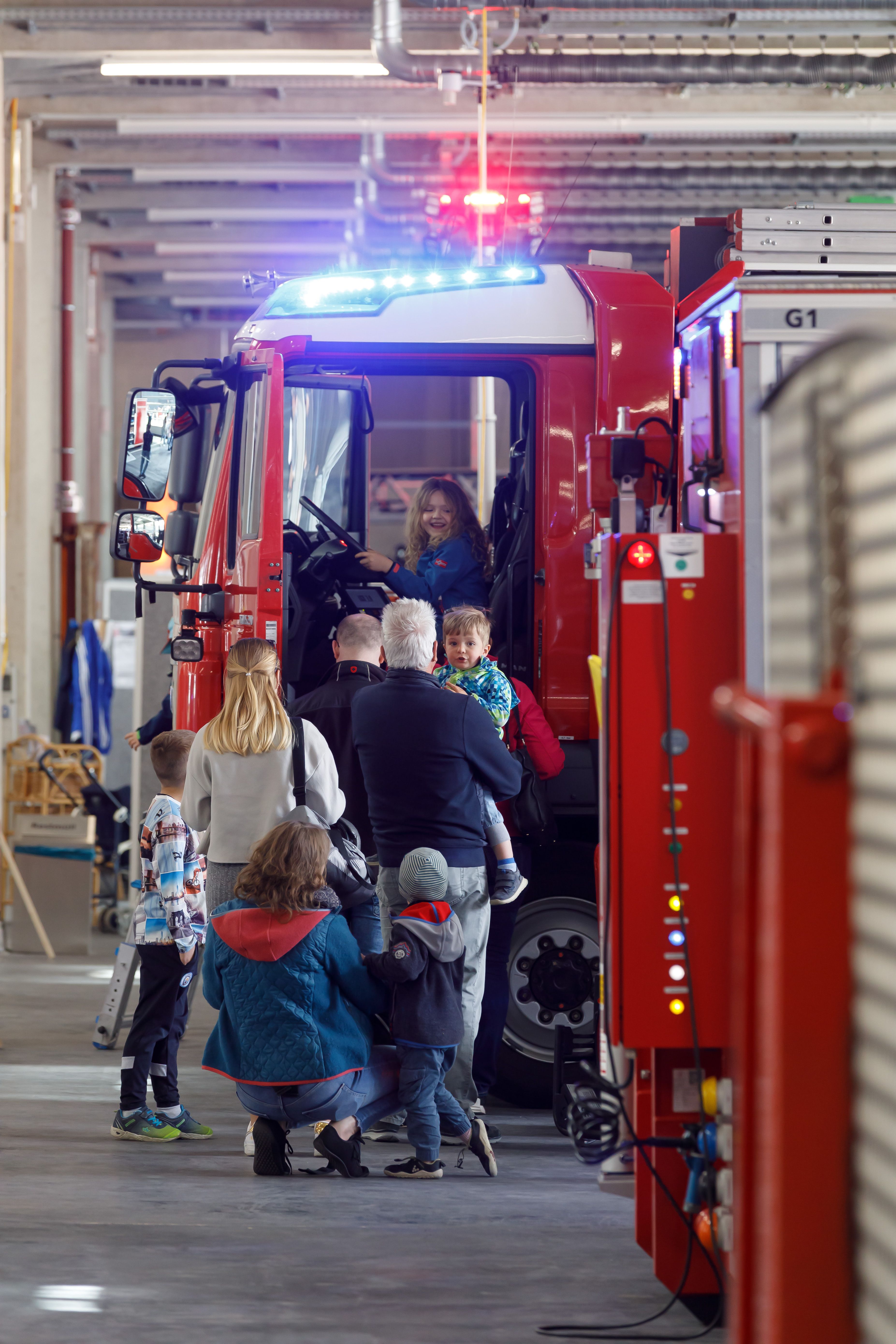 Fotografie: Familien besichtigen Feuerwehrfahrzeuge.