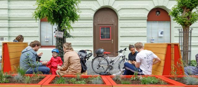 Fotografie - Menschen auf Bänken in Obermünsterstraße
