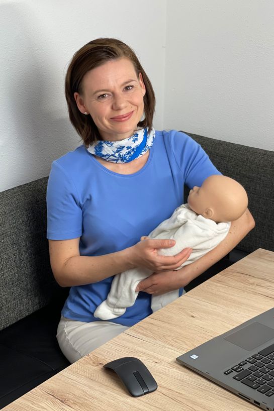 Fotografie: Kursleiterin Nancy Moleda mit einer Babypuppe auf dem Arm (C) Nancy Moleda
