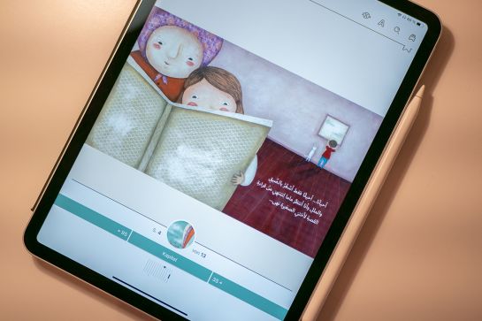 Fotografie - Auf einem Tablet ist ein arabisches Kinderbuch geöffnet.