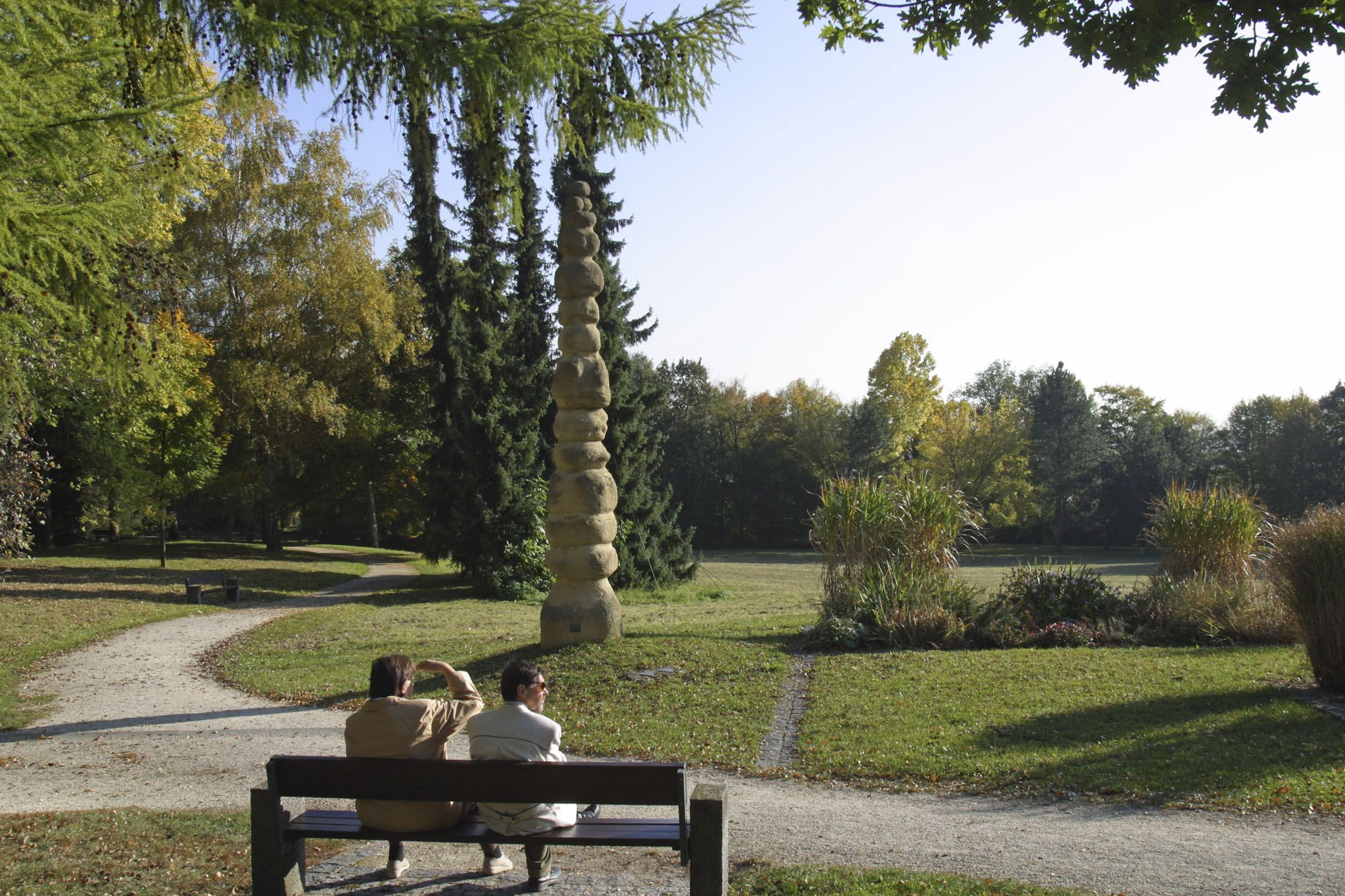 Fotografie: Zwei Personen sitzen auf einer Bank im Tempe-Park.