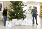 Fotografie - zwei Personen vor einem Weihnachtsbaum mit Geschenken (C) Bilddokumentation Stadt Regensburg