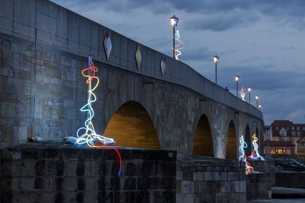 Blick auf die beleuchtete Steinerne Brücke während des Regensburger Lichterfests 2024.