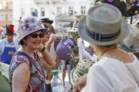 Fotografie: Eine Frau probiert einen Hut an. (C) Bilddokumentation Stadt Regensburg