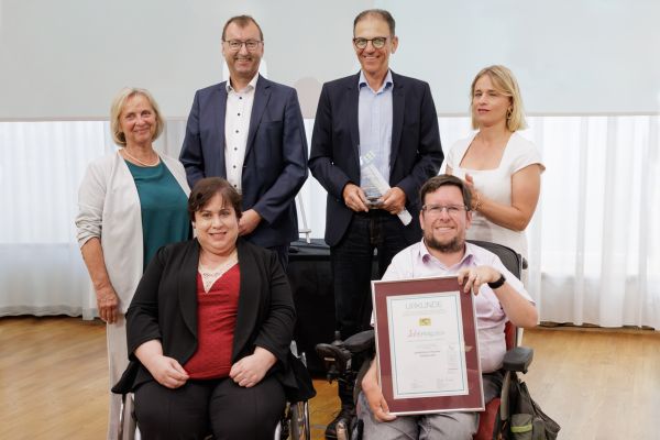 Fotografie: Angelika Krüger (Werkhof Regensburg), Wolfgang Eberl (Inklusionsamt ZBFS), Rolf Frey (Lebenshilfe Regensburg) (hinten), Marion Thätter (Phönix e. V.) und Frank Reinel (Stadt Regensburg) (vorne) erhielten den JobErfolg 2024 aus den Händen von Verena Bentele, Präsidenten des VdK (r.)