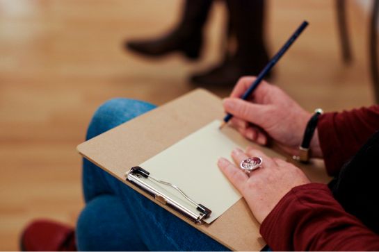 Fotografie: Kursteilnehmerin mit Stift und Zettel