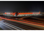 Fotografie - das Regensburger Jahnstadion leuchtet in der Nacht, im Vordergrund die Autobahn