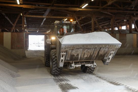 Fotografie: Transport des Streuguts mit Bagger im Depot des Winterdienstes