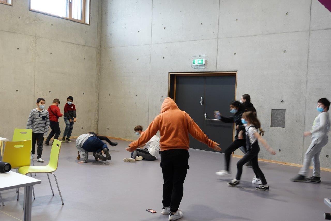 Auf dem Foto sind mehrere Kinder und Jugendliche zu sehen, welche ein Spiel in einer Halle spielen.