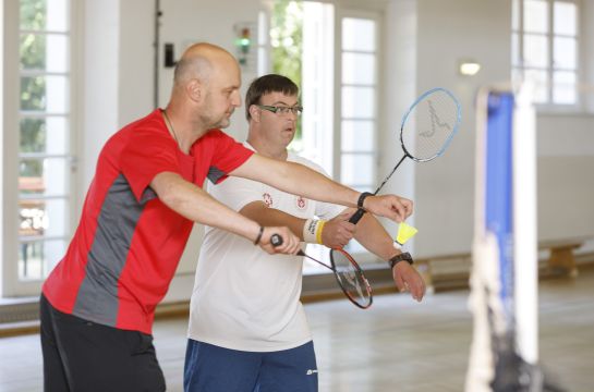 Fotografie: Zwei Männer spielen Badminton.