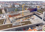 Fotografie - Baustelle mit dem Rohbau und den bereits fertiggestellten Gebäuden