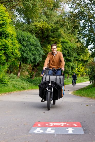 Fotografie: Nahmobilitätskoordinator Thomas Großmüller fährt mit einem E-Lastenrad auf der Hauptradroute rr05.