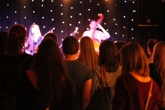 Konzert der Künstlerin "Missincat" im W1 - Zentrum für junge Kultur. Im Vordergrund Publikum von hinten mit Blick zur Bühne, auf der verschwommen die Band zu erkennen ist.