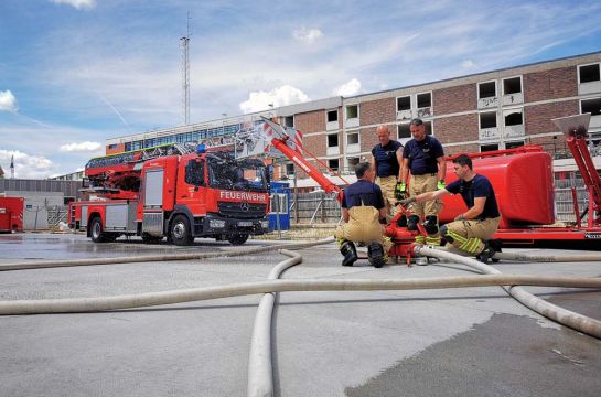 Feuerwehrbeamte bei der Ausbildung an einem Schaum - Wasserwerfer