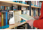 Fotografie - Eine Person liest sich den Buchrücken eines Romans durch. © Susanne Jakowski